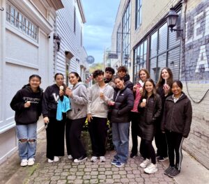 Image of students in a city alley posing with ice cream.